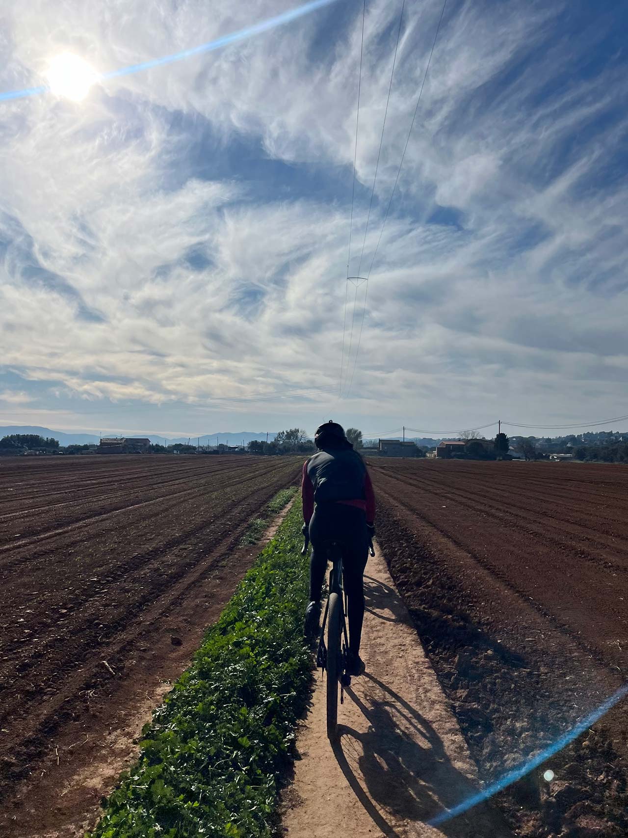 ciclista de gravel POV en un sendero muy estrecho entre campos