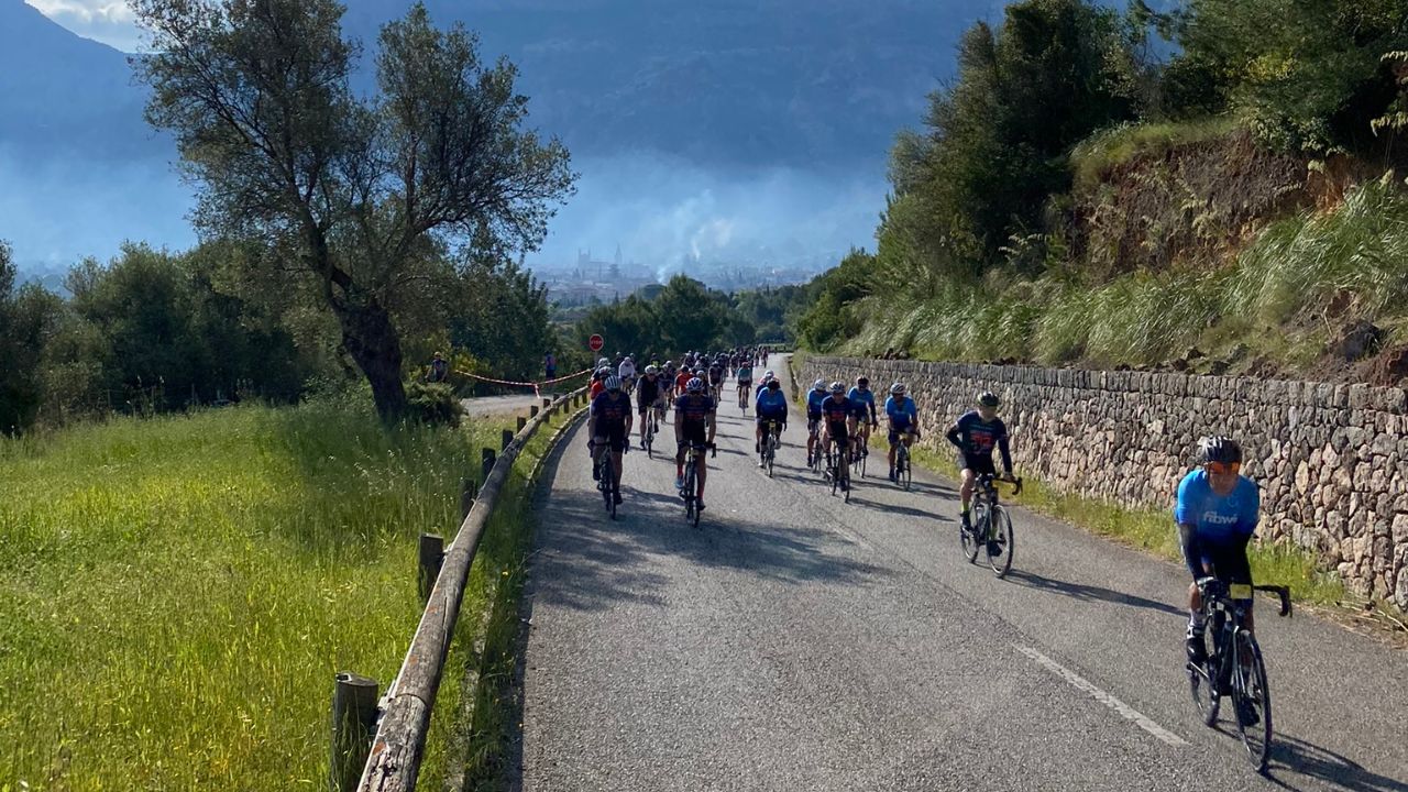 Grupo de ciclistas participantes en la Mallorca 312 con un paisaje espectacular detrás